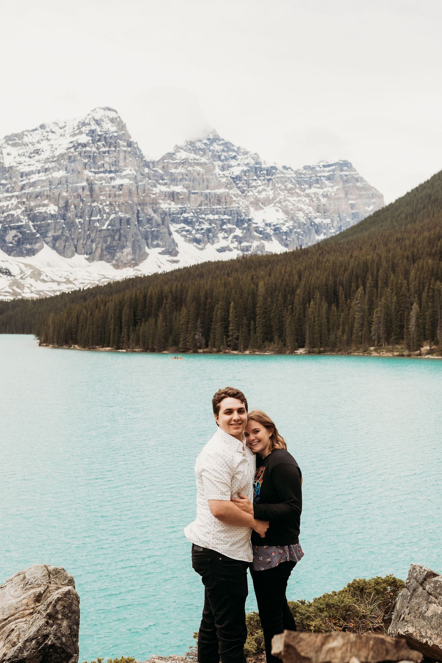 A tender moment captured at Moraine Lake with majestic Rocky Mountains in the background.