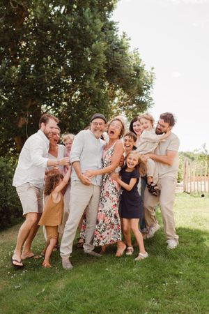 Family members laugh together during a casual outdoor photography session.