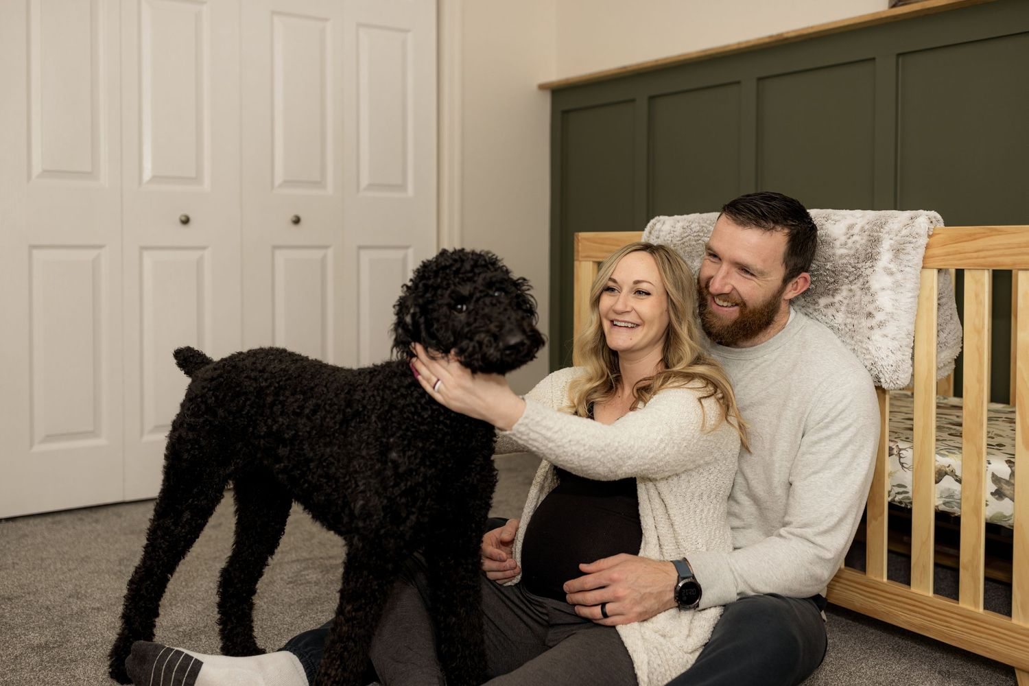 Loving couple shares tender moment with their pet dog in home setting.