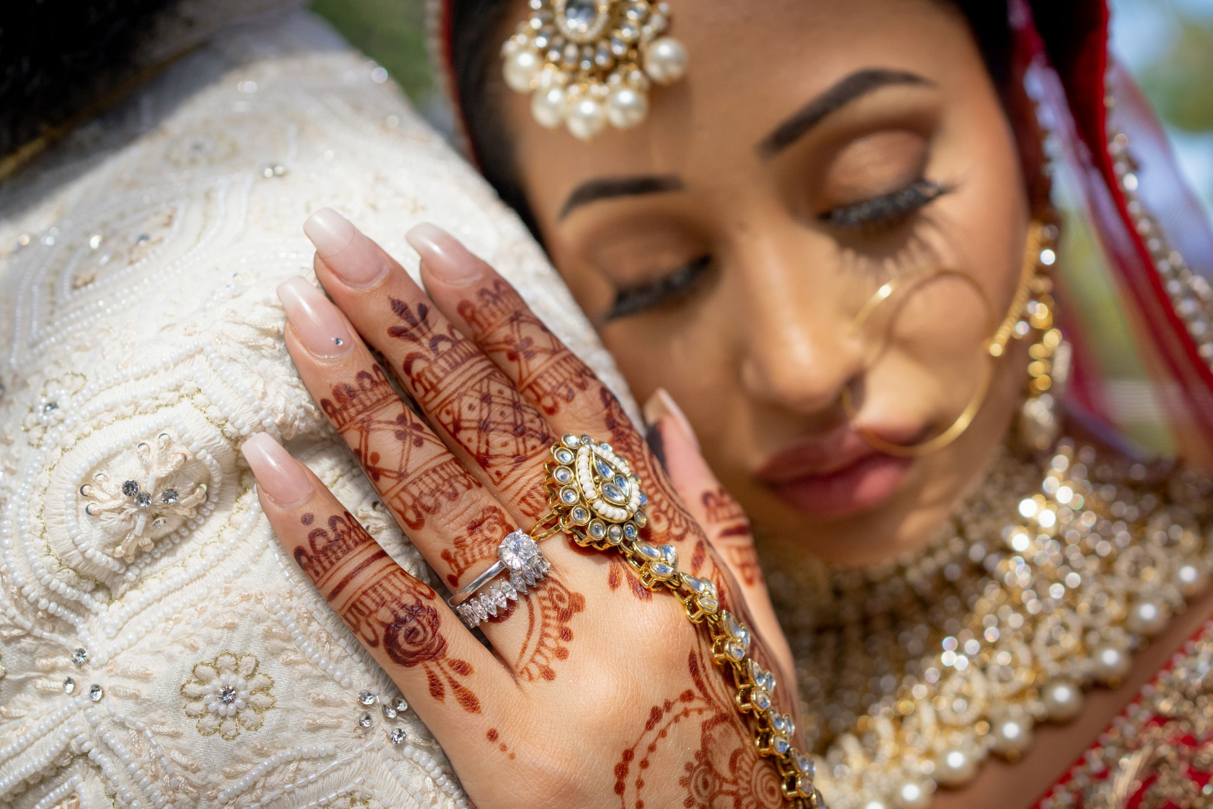Intricate henna design on palm with traditional Indian bridal jewelry.