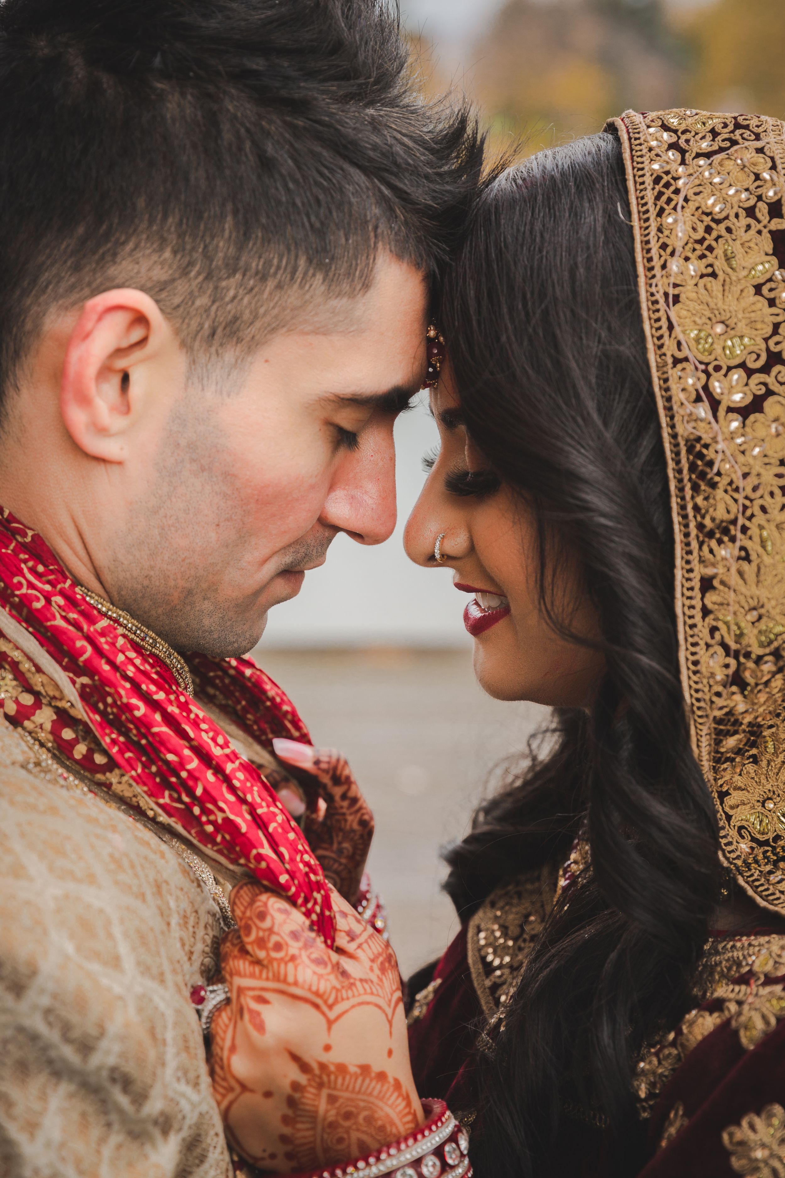 Intimate close-up of couple in traditional South Asian wedding attire.