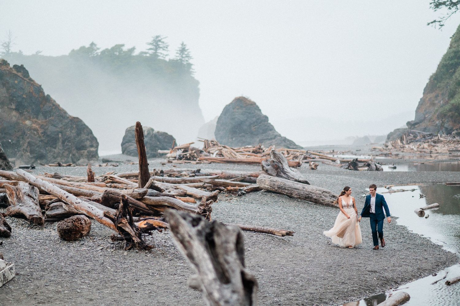 wedding couple running on Ruby Beach in Olympic National Park