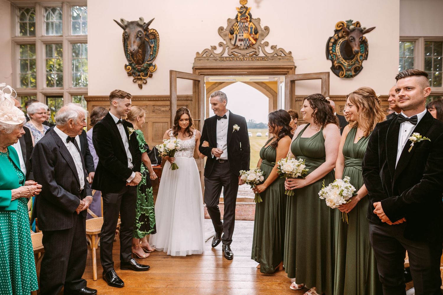 Wedding ceremony in elegant historic room with ornate decor and guests in formal attire.
