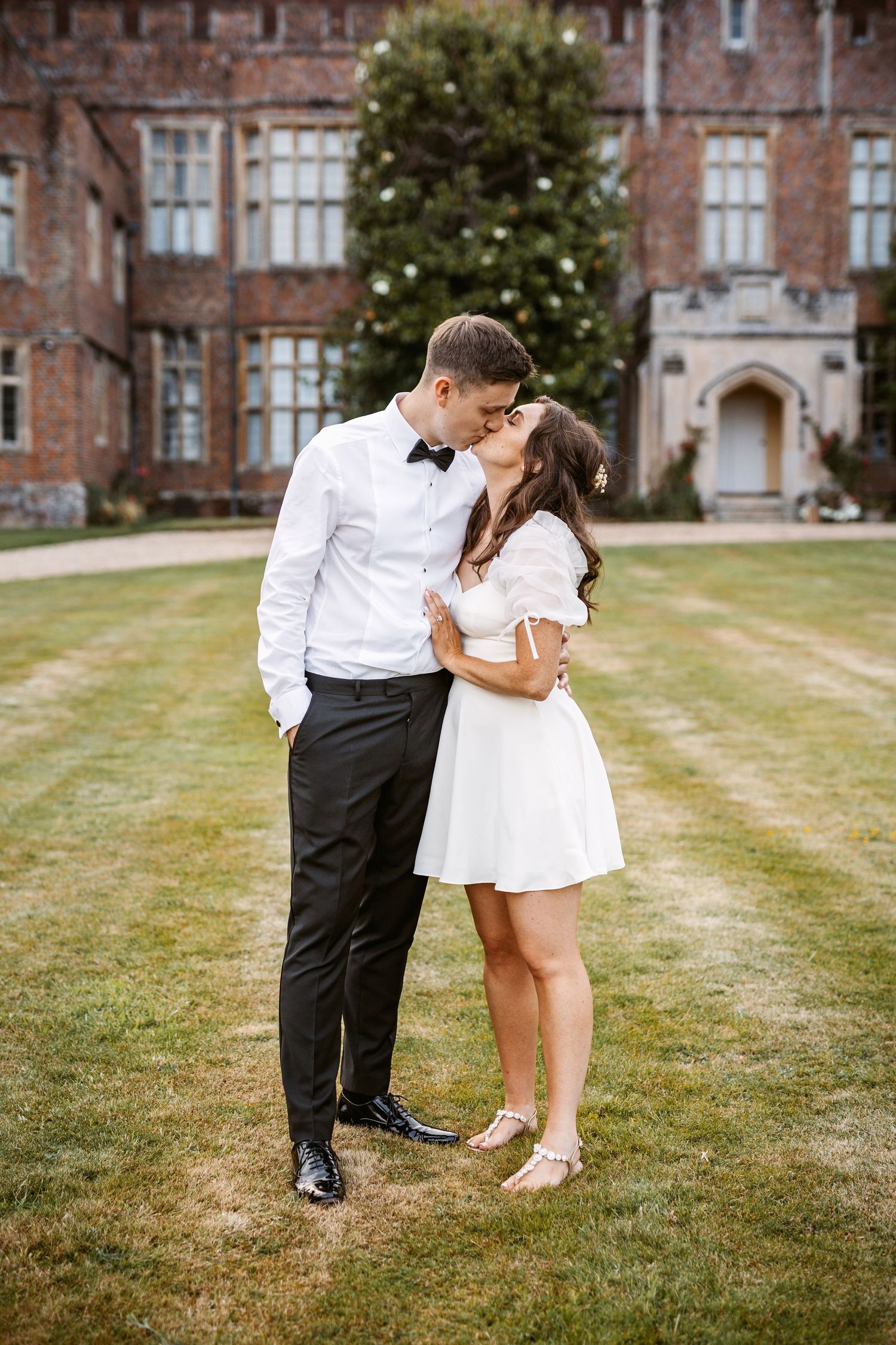 Romantic moment captured on the lawn of a grand historic brick mansion.