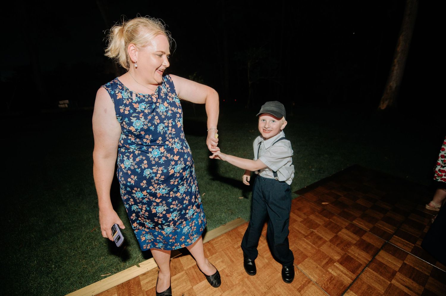 Dancing partners share a sweet moment on outdoor dance floor at night.