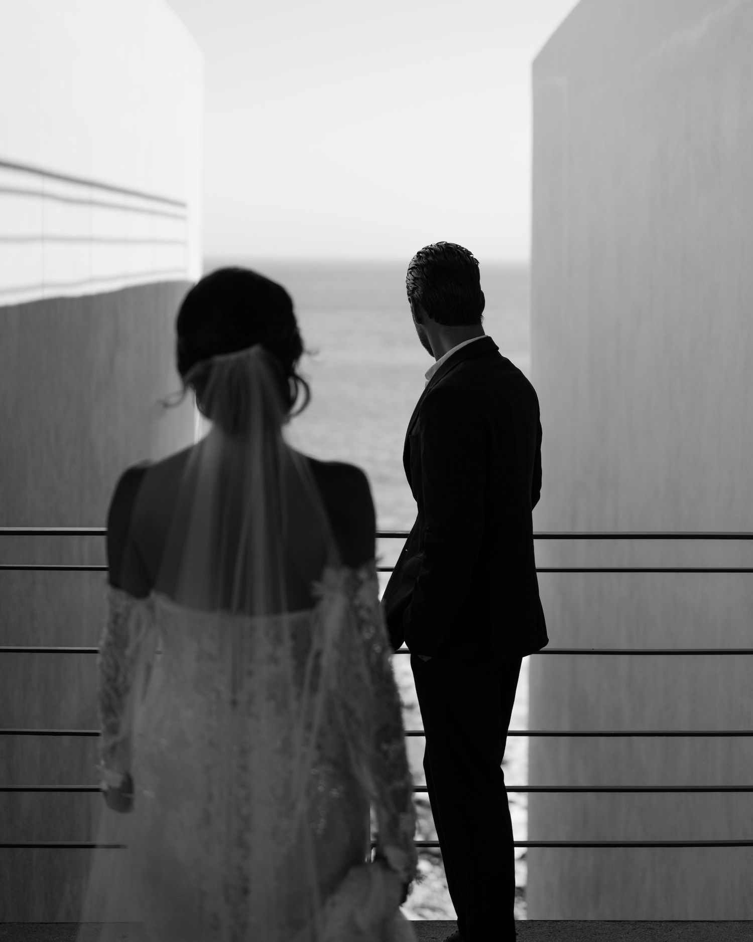 Black and white silhouettes of people against bright architectural elements.