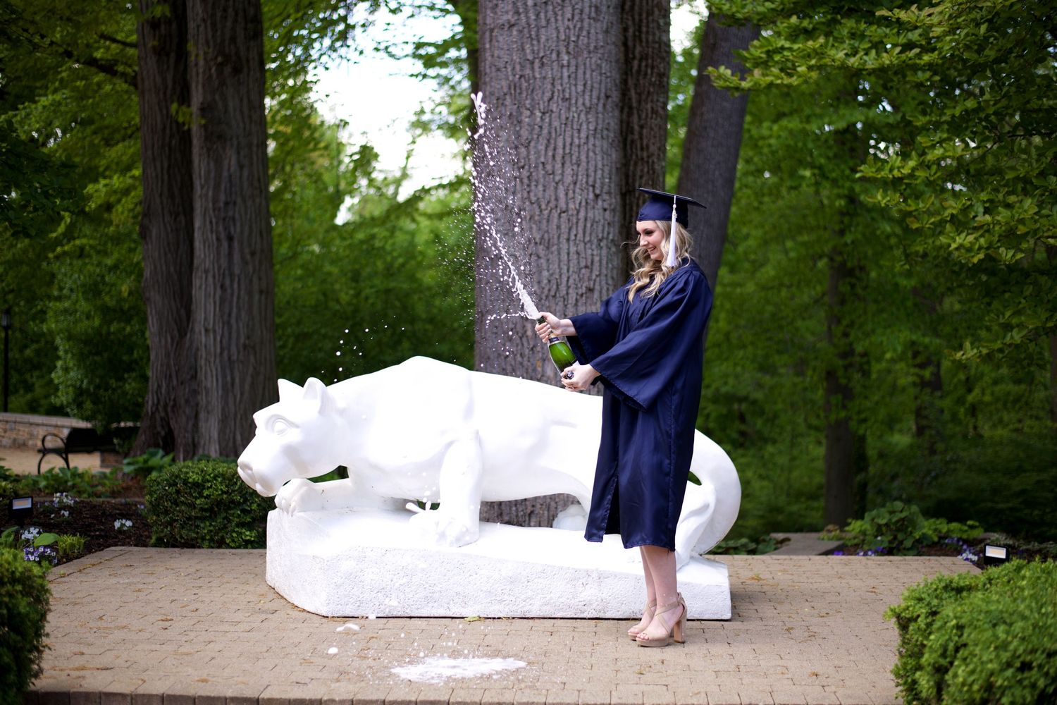 graduation cap and gown; celebrate; popping champagne; Penn State grad; campus photo; celebration