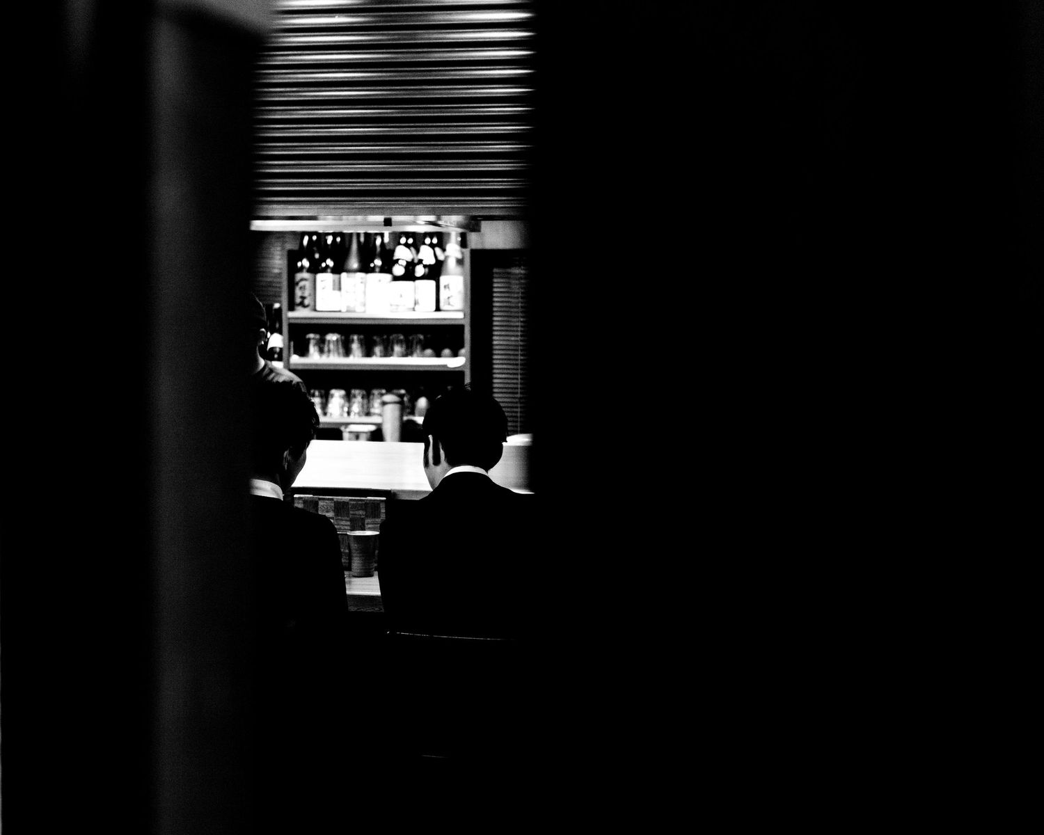Black and white photo of two office workers sharing a late meal in Tokyo Japan