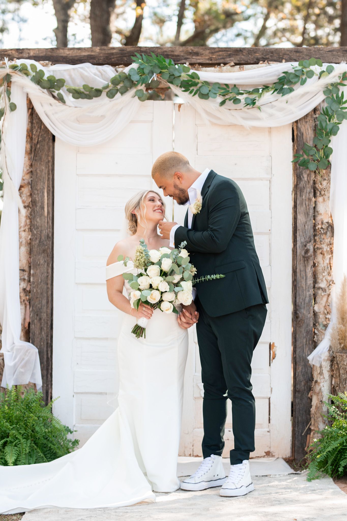 Bride and groom wedding pictures outdoor in front of vintage doors at Sanctuaire Atelier.