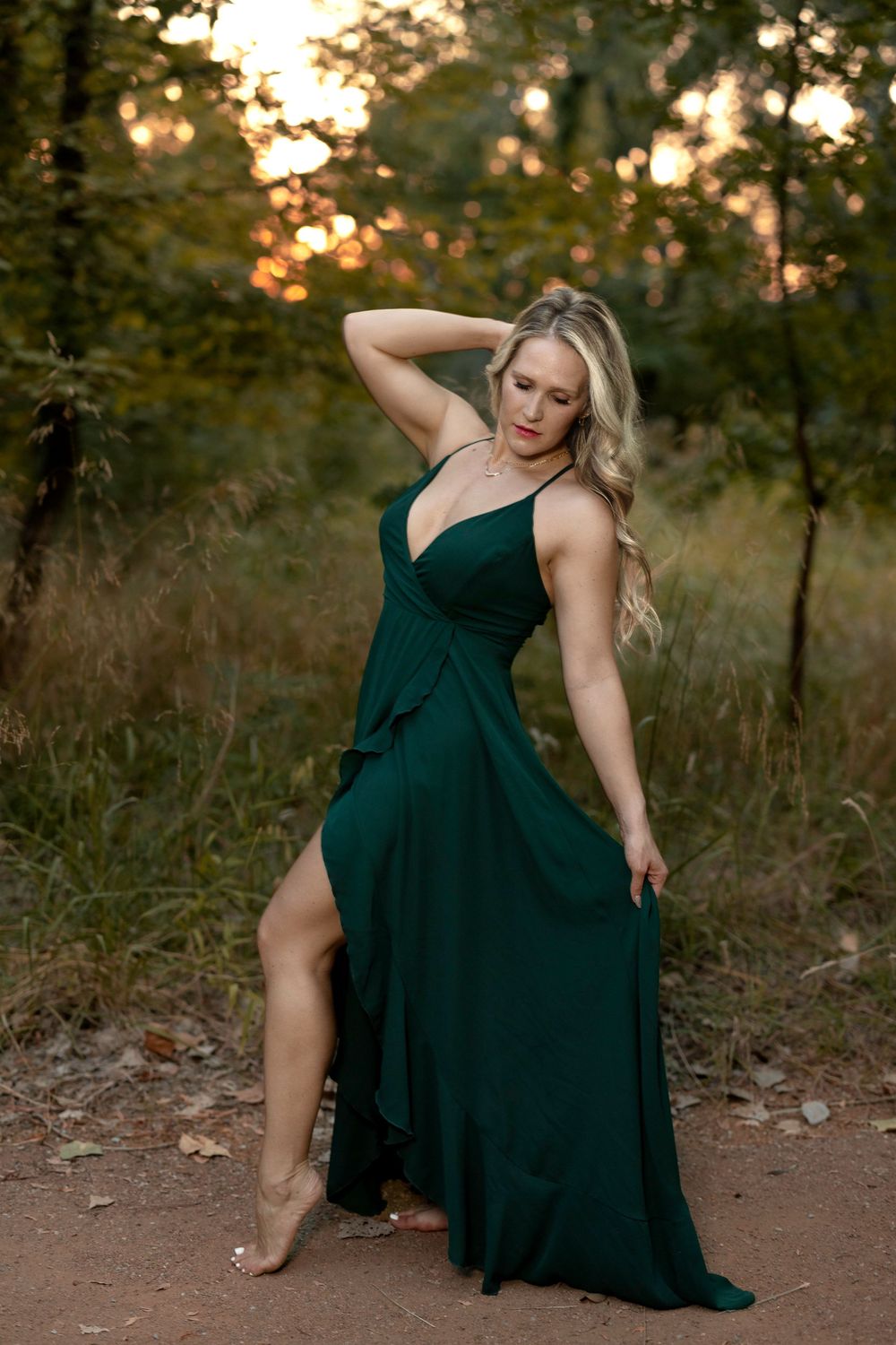 Emerald green evening gown with thigh slit photographed in nature at sunset.