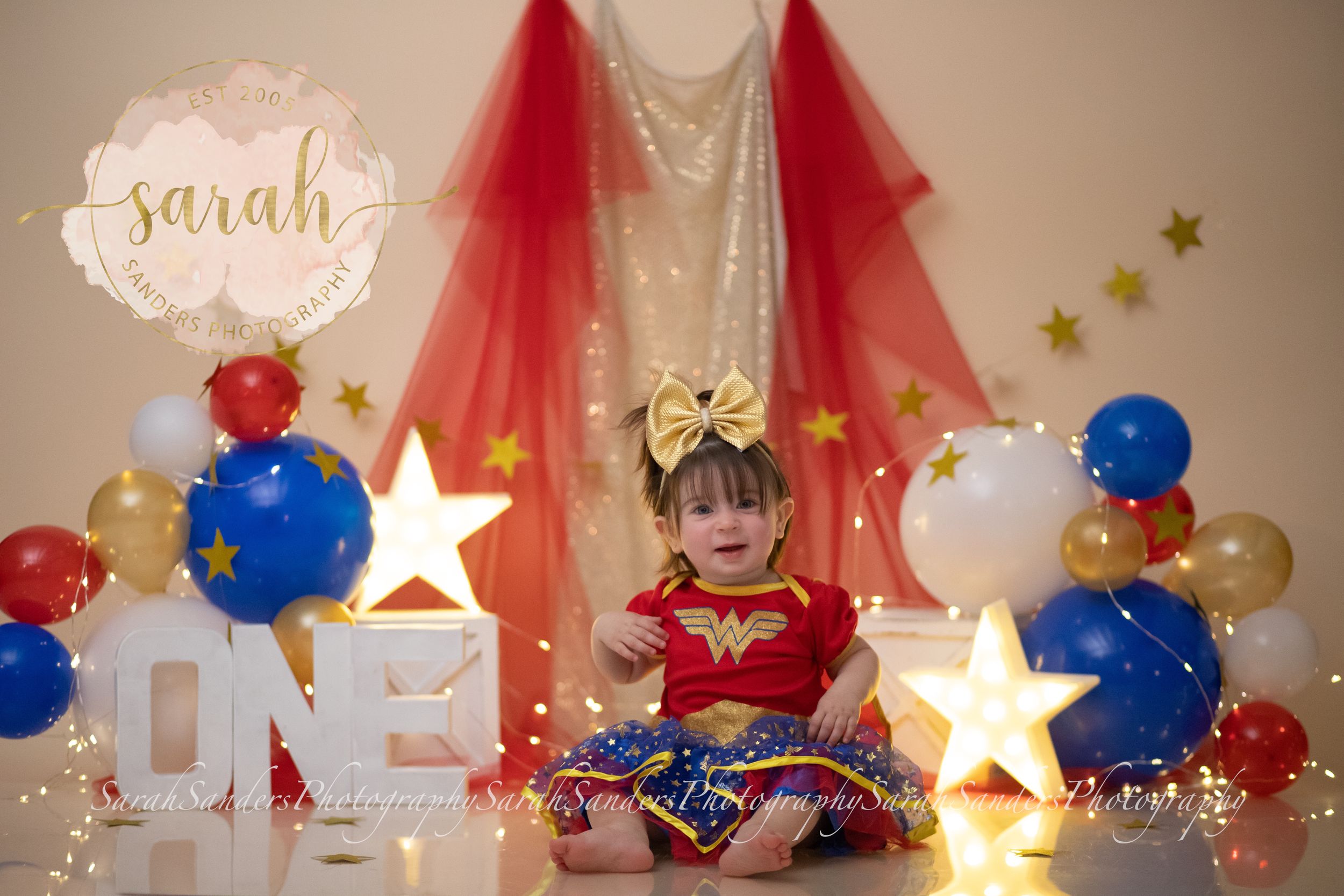 Baby sitting with cake in a star themed set