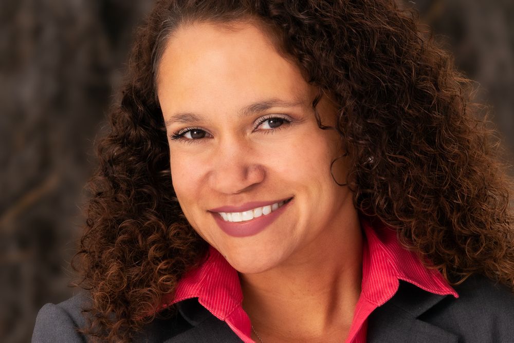 headshot close-up portrait of a woman with brown curly hair