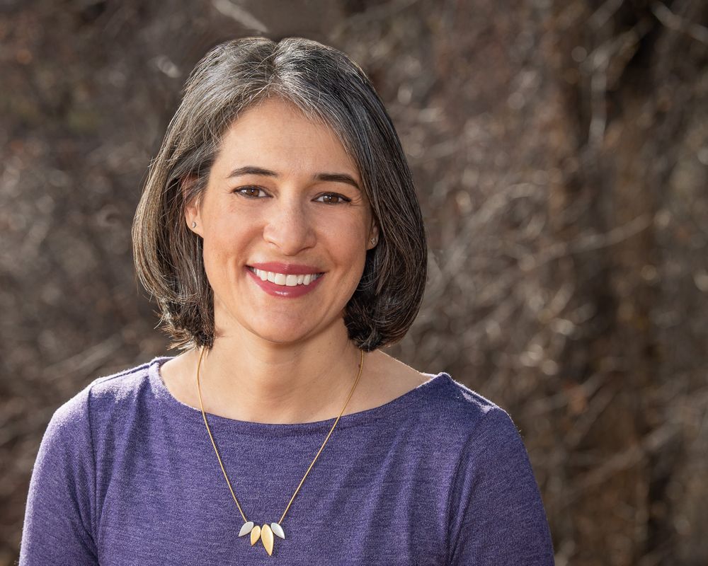 Headshot portrait of a woman with brown nature background