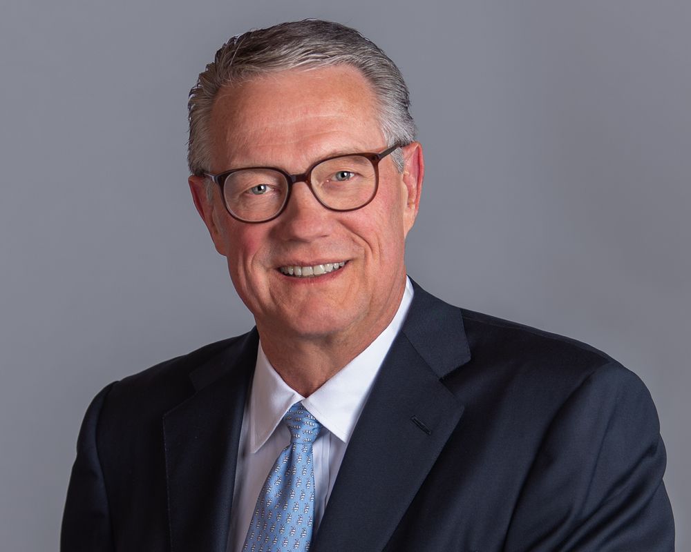 Headshot portrait of a man with grey bakcground