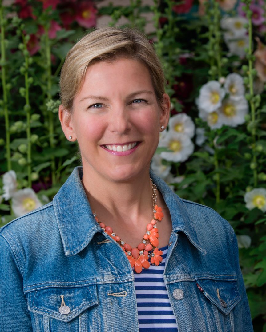 Headshot portrait of a woman with flowers in background