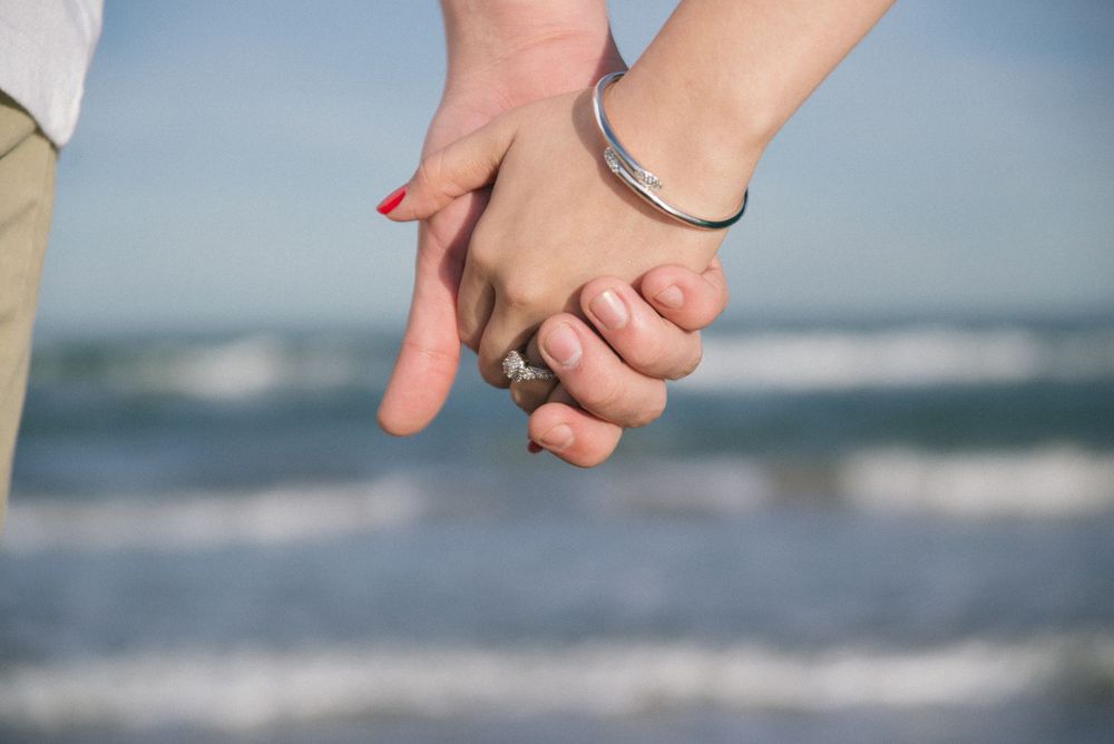 couple holding hands at the beach. engagement couple session. south padre island. wedding photographer
