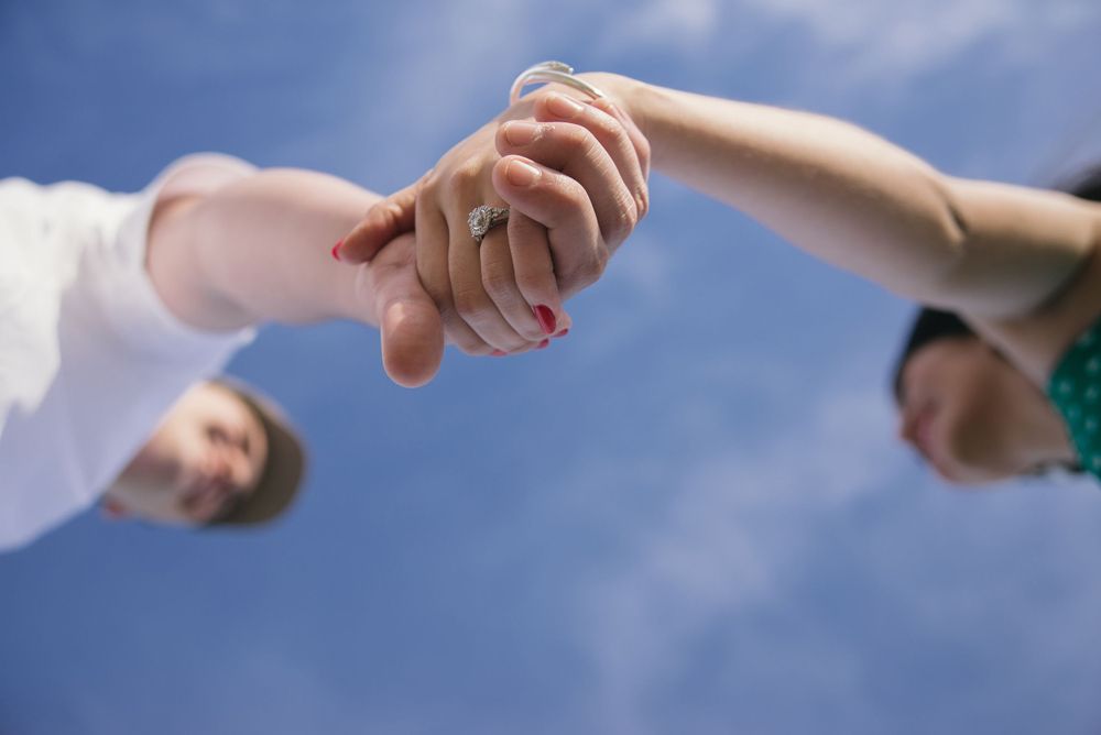 couple holding hands. engagement ring. south padre island. wedding photographer