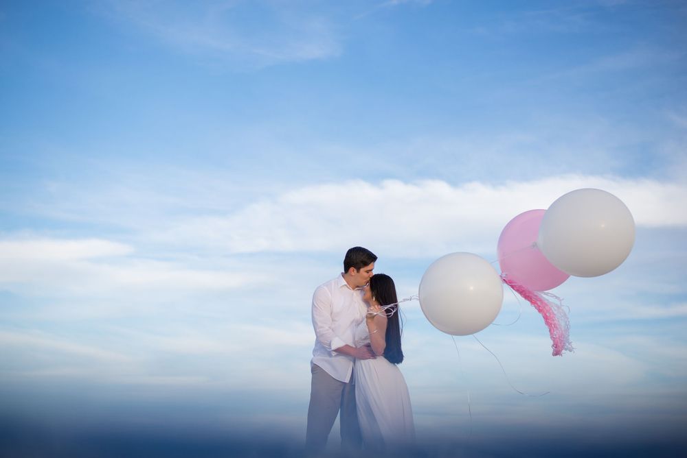 man kissing lady's forehead. balloons. beach. sand. south padre island. wedding photographer