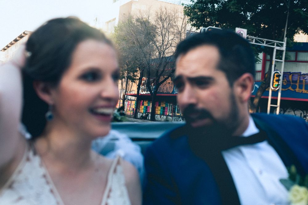 An intimate candid moment between newlyweds on their wedding day in an urban setting.