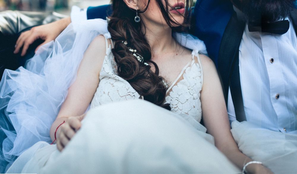 Close-up detail of a white lace wedding dress and elegant bridal styling.