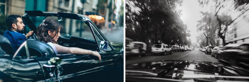 Vintage convertible car carrying wedding couple through city streets.