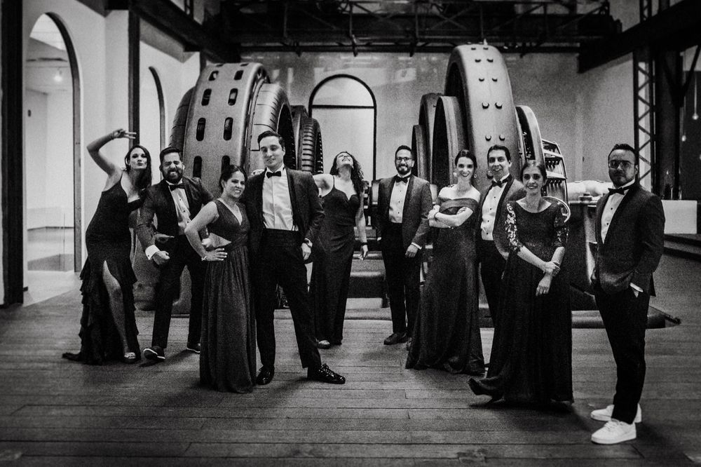 Formal wedding party in black and white standing in elegant indoor venue.