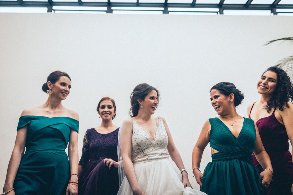 Wedding party lineup features bridesmaids in elegant emerald green dresses.