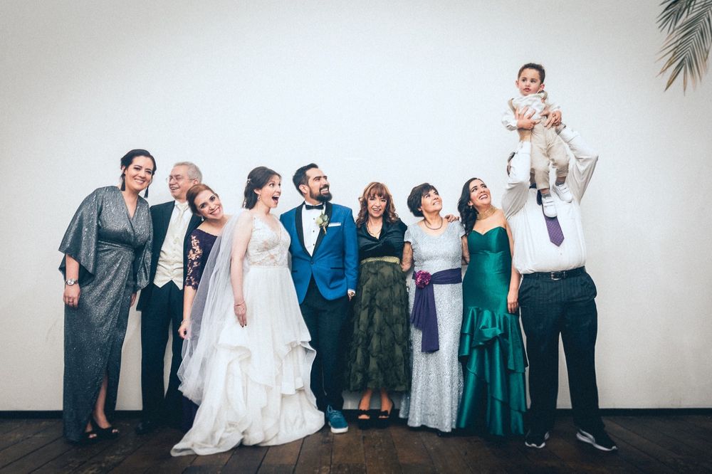 Wedding party poses for group photos with bridesmaids in emerald dresses.