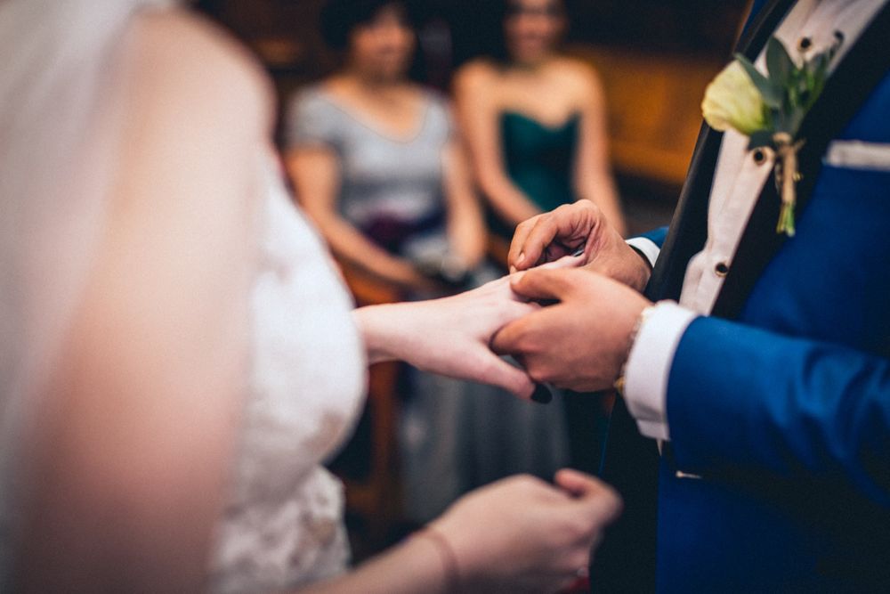 Close-up of hands during an emotional wedding ceremony exchange.