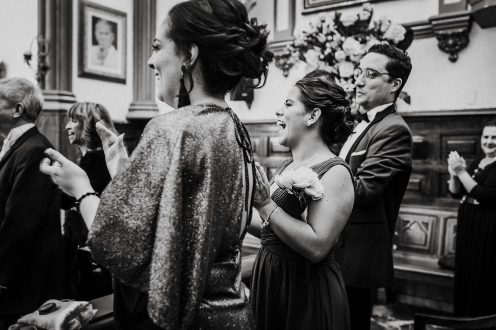 Black and white photos of wedding guests celebrating in a traditional venue.