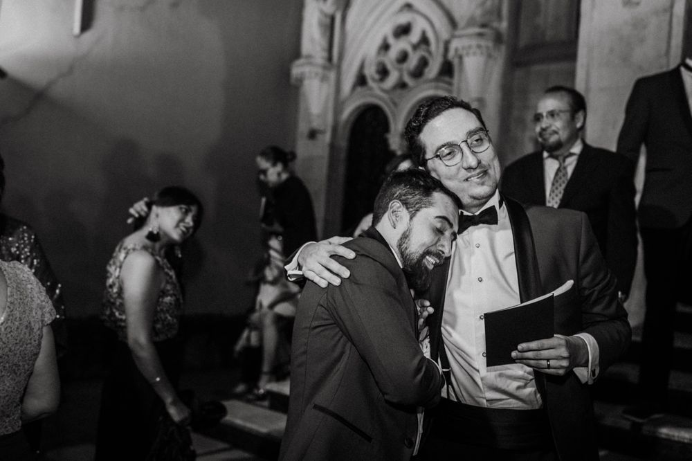 Wedding guests mingling in an elegant vintage-style venue with ambient lighting.