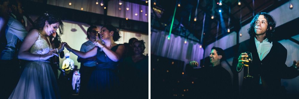 Wedding party guests dancing and celebrating with glow sticks on dark dance floor.