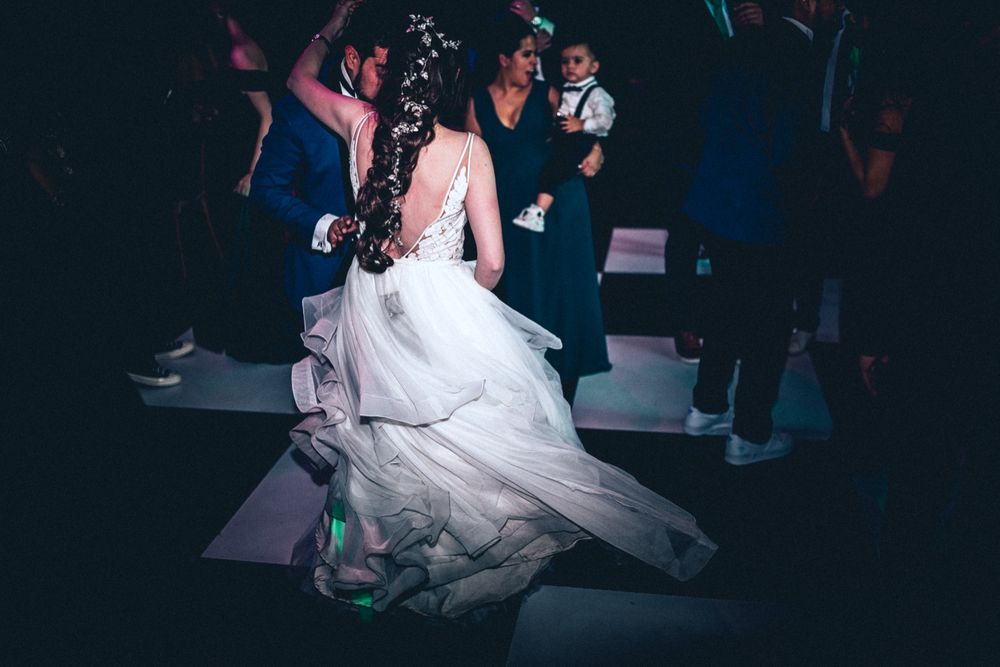 Bride's flowing white dress twirls dramatically during reception dance.