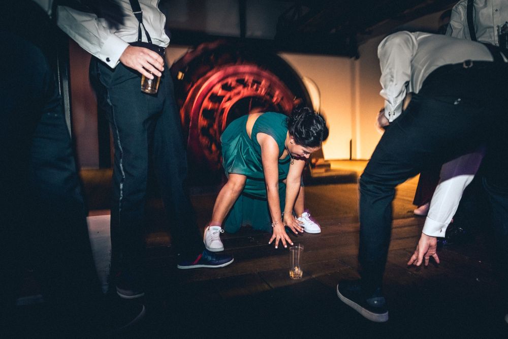 Wedding guests dance energetically on the dance floor during a reception party.