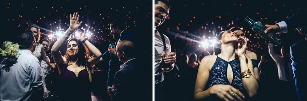 Guests celebrate with sparklers and flashing lights during an energetic wedding reception.