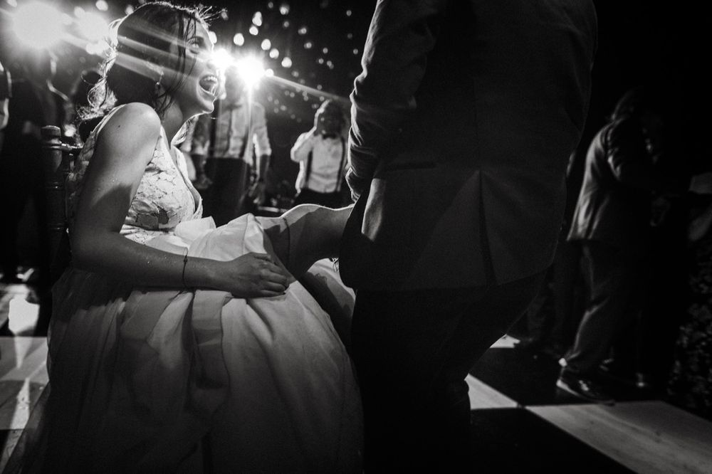 Dramatic black and white wedding party scene with sparklers and dancing silhouettes.