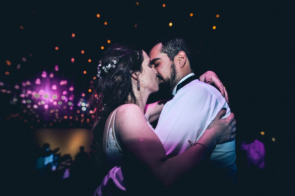 Romantic evening dance scene with colorful bokeh lights and dancing couples in silhouette.