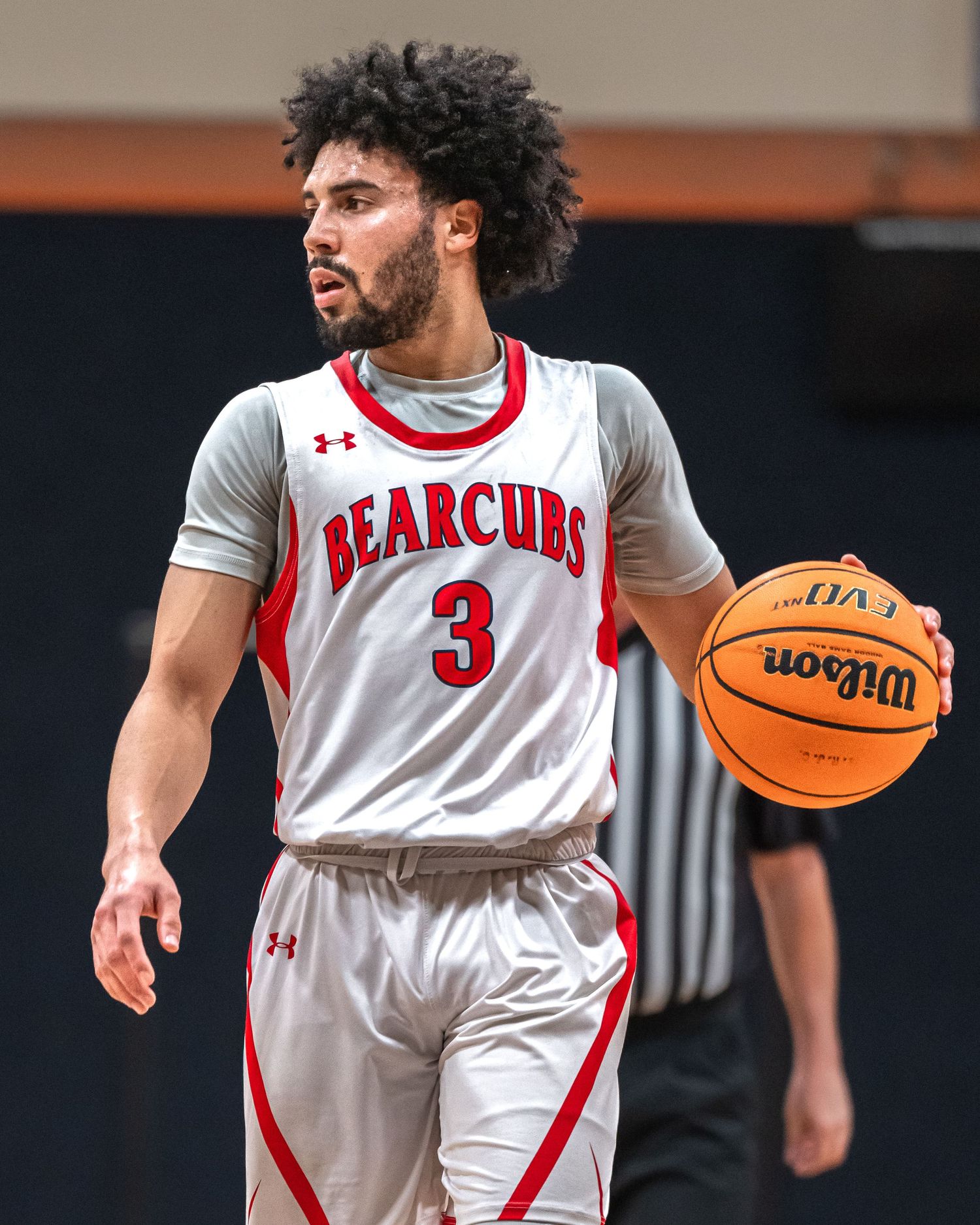 Basketball player in white Bearcubs jersey number 3 controls ball during game.