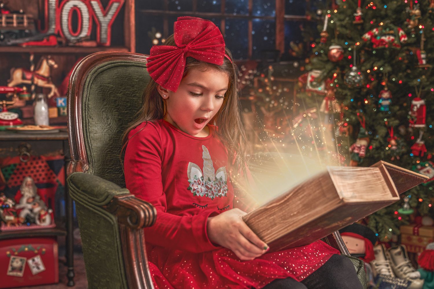 Girl sitting on antique green silk chair in red dress with Christmas surprise book