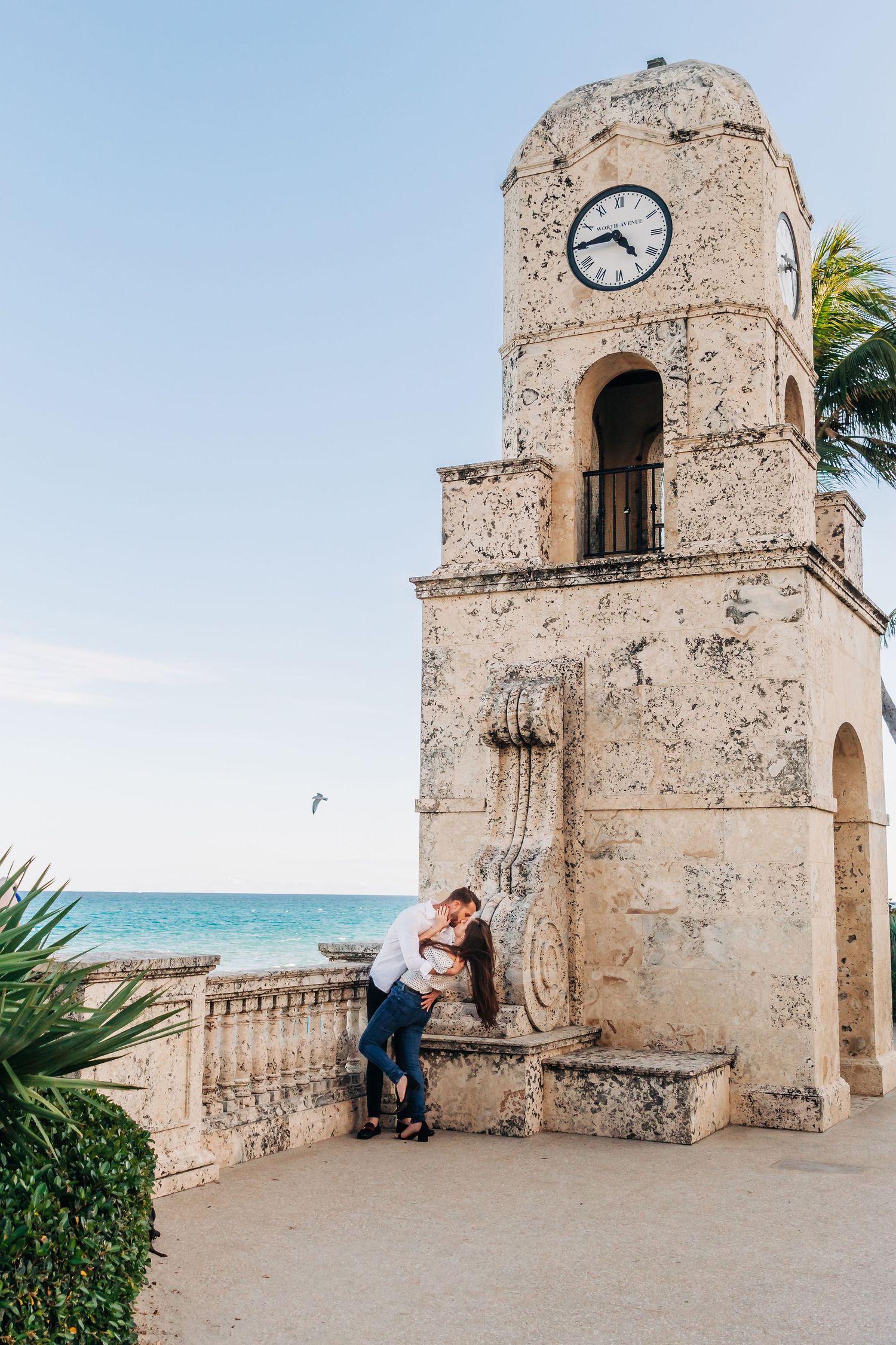 Historic clock tower overlooking ocean with ornate stone architecture and palm trees in palm beach, Worth ave clock tower