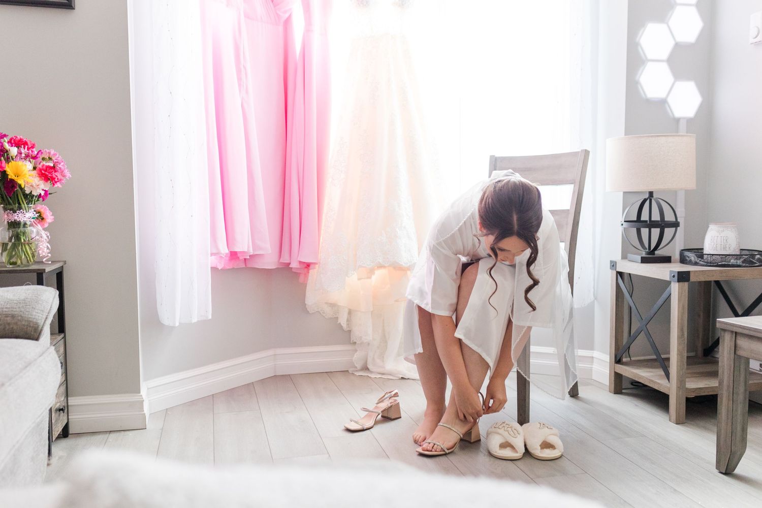 Pink and white decor elements in a bright getting ready room with shoes and robes visible.