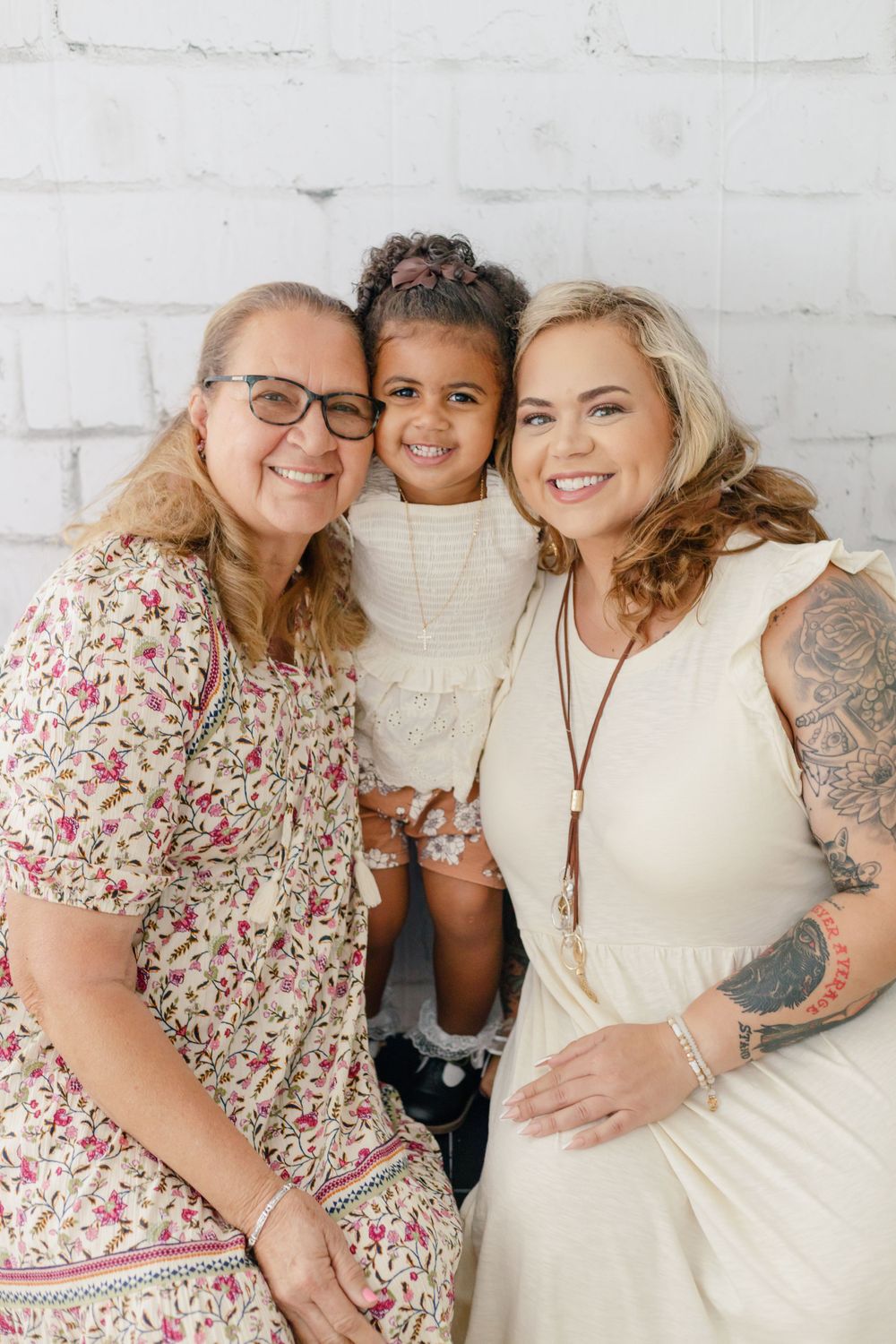 Heartwarming family portrait against white brick wall background.