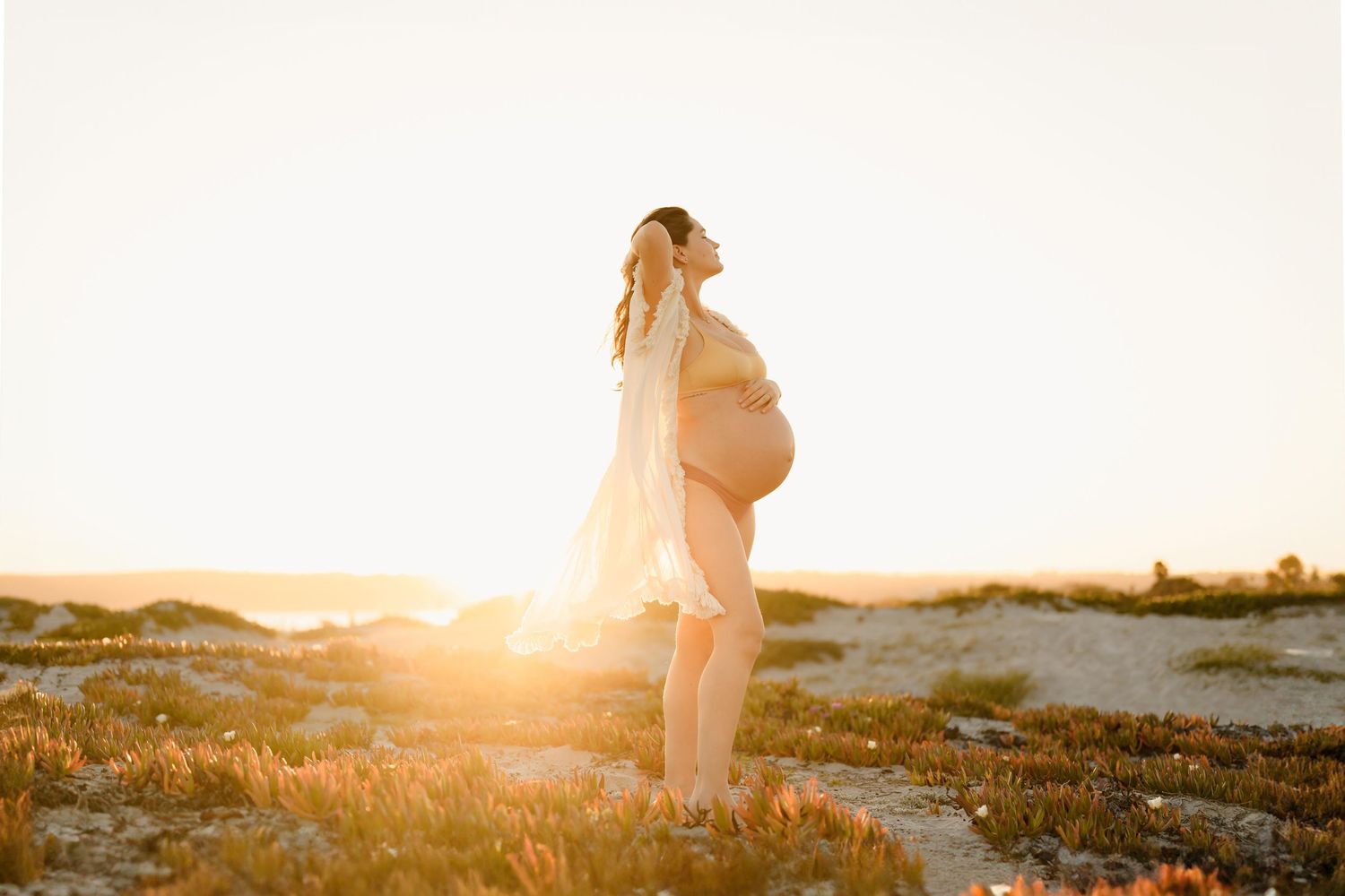 Maternity bare belly portrait at Coronado Beach by San Diego photographer, Tiffany Kelterer, of woman in bathing suit