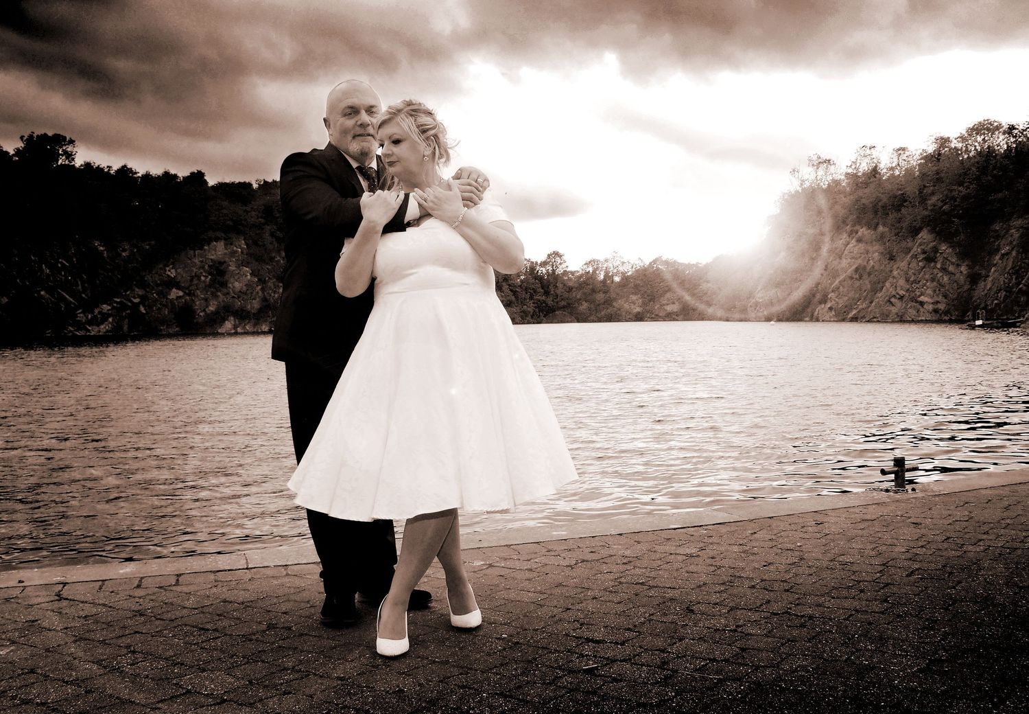 Wedding Photographer Warwickshire - Bride and Groom hugging in a dramatic setting at sunset
