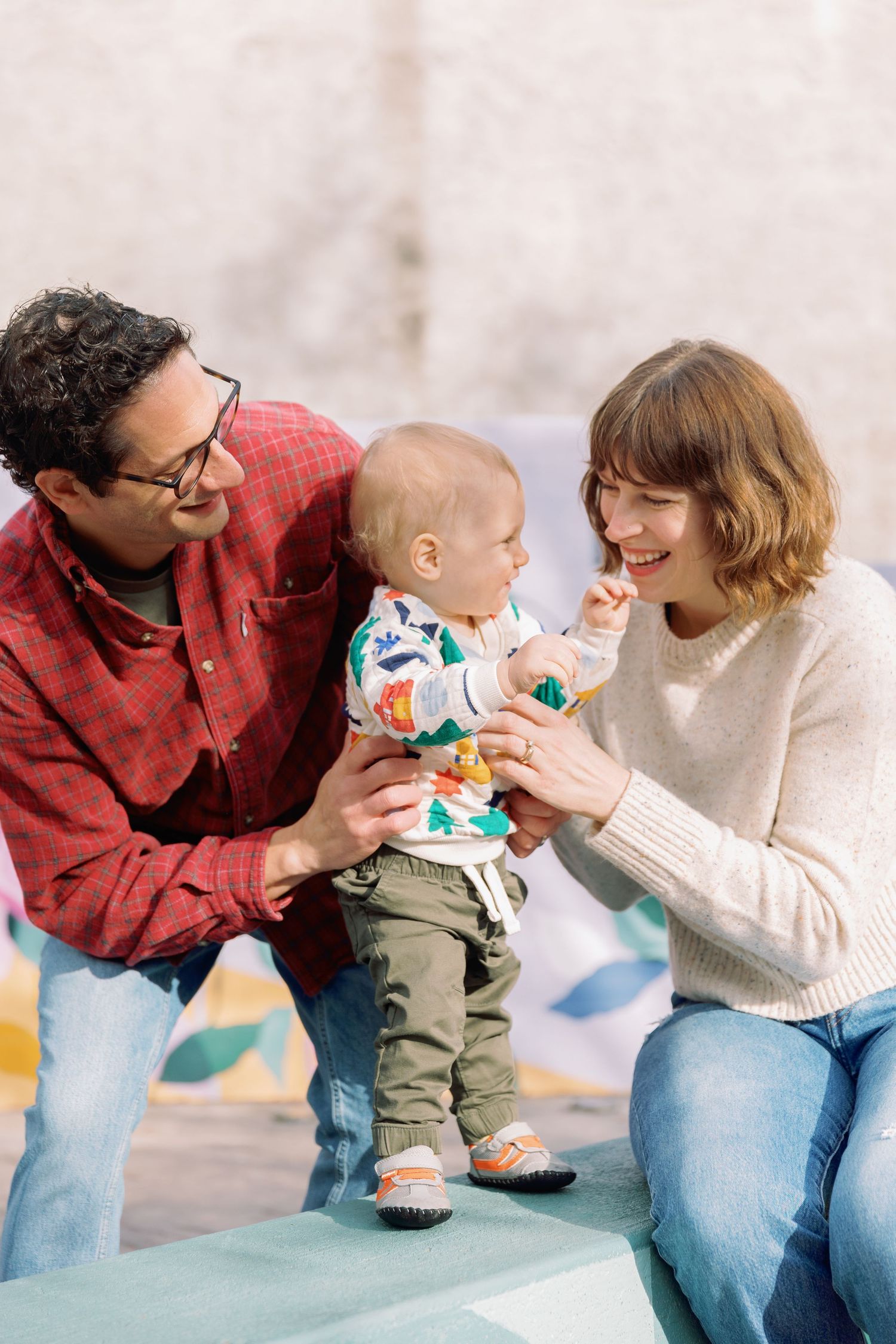 Family sharing tender moment together outdoors in casual clothing.