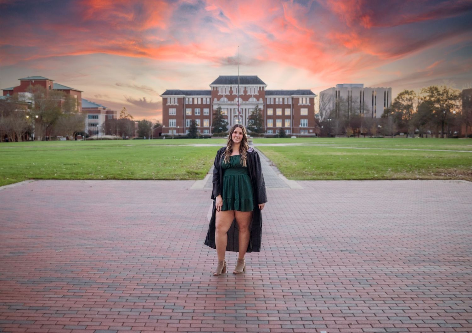 Senior stands on MSU's drill field with sunset behind her