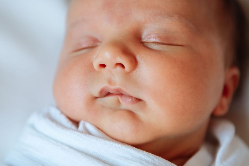 A newborn baby swaddled gently in Denver