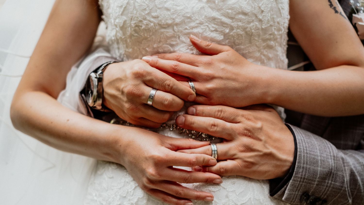 Groom with hands around waist of bride at wedding