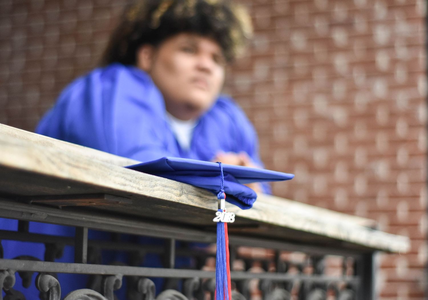 Senior graduation portrait in a blue cap and gown outdoors