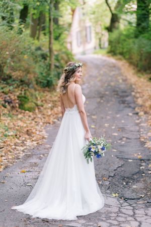Hochzeitsfotografie - Braut auf Feldweg mit Brautstrauß - Hofgut Hohenstein Lautertal